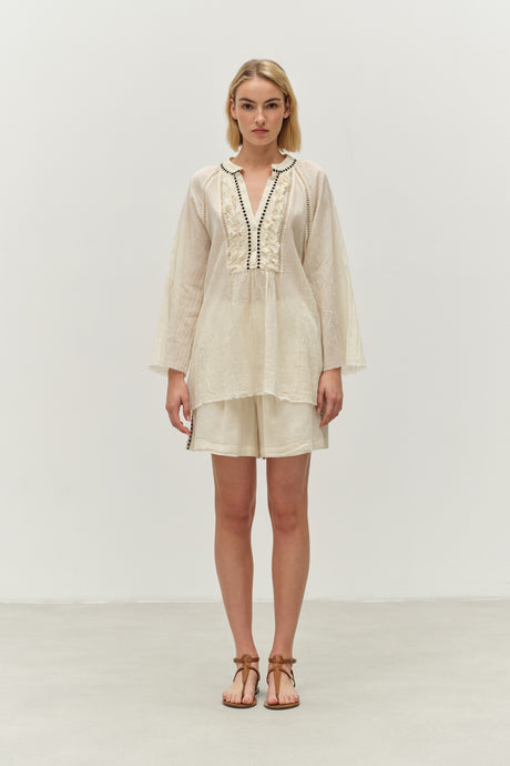 Off-white long-sleeve blouse with lace trim and V-neckline paired with matching shorts.