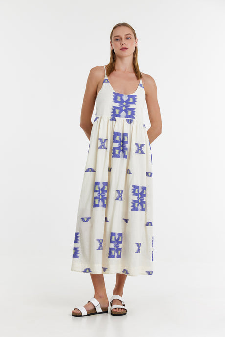 White sleeveless maxi dress with blue geometric jacquard patterns and square neckline.