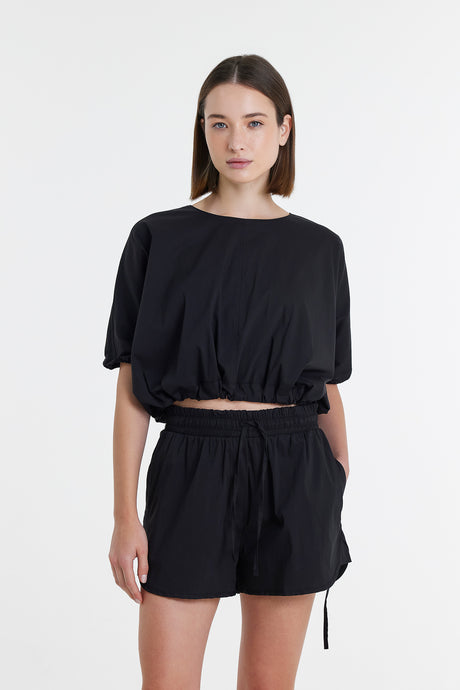 Black loose-fit short-sleeve crop top with matching high-waisted shorts in lightweight fabric.
