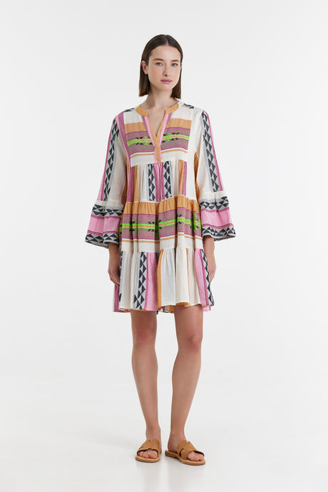 Short multicolored jacquard dress with wide bishop sleeves and a V-neckline, styled with flat sandals.