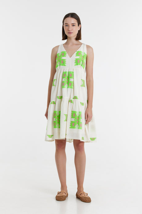 Sleeveless short dress with green and fuchsia jacquard floral pattern on white background and V-neckline.