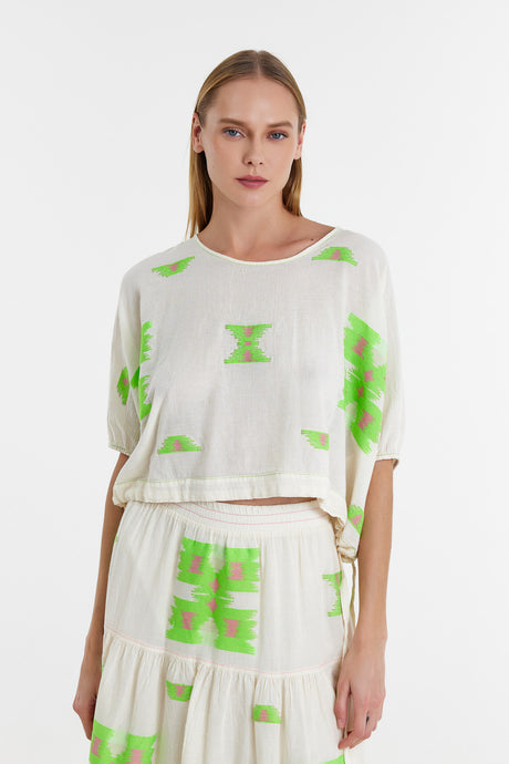 White blouse with green geometric jacquard patterns and loose three-quarter sleeves.