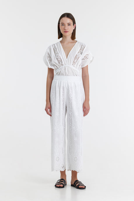 White lace wide-leg pants with high waist and delicate floral embroidery.