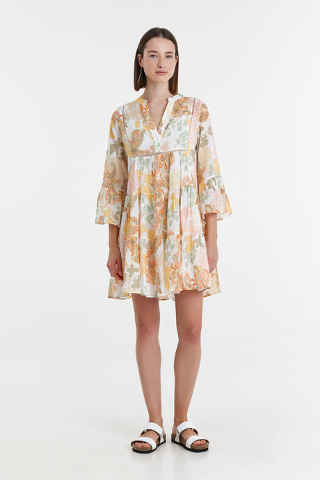 Yellow short floral print dress with v-neck and flared sleeves paired with black and white sandals.