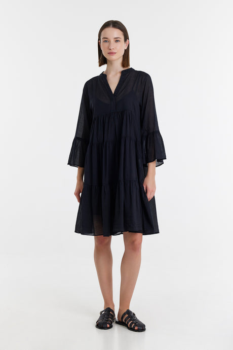 Black midi dress with three-quarter bell sleeves and V-neck, worn with black sandals.