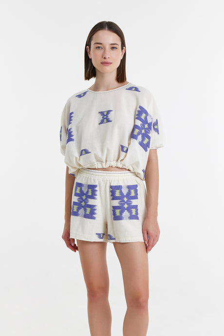 White jacquard shorts and matching short-sleeve top with blue and lime geometric patterns.