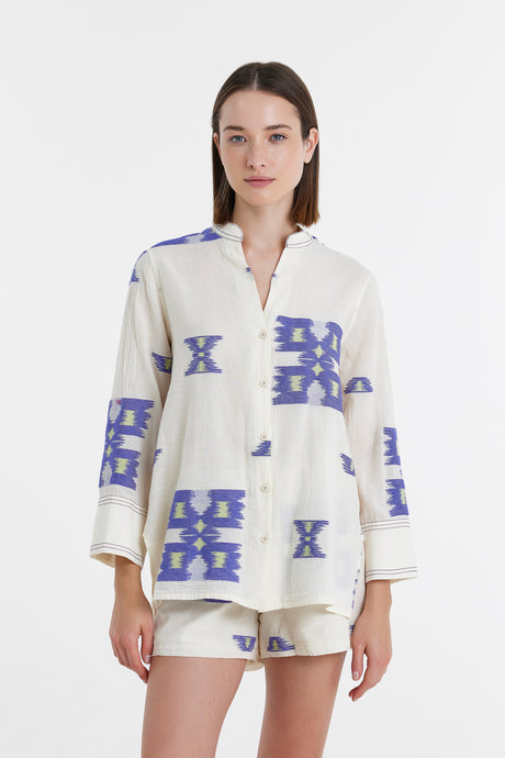 White jacquard blouse with oversized blue geometric patterns and loose sleeves.