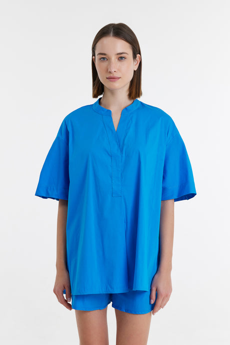 Turquoise loose-fit popeline blouse with short wide sleeves and a partial front placket.