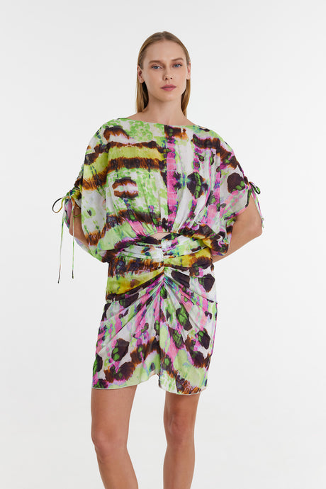 Short-sleeve blouse dress with green, pink, and black abstract tie-dye print, ruched waist, and side drawstrings.