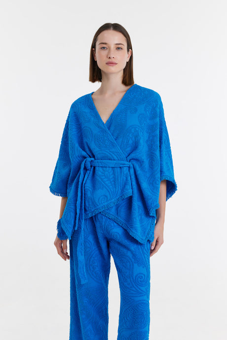 Blue kimono-style blouse with wide sleeves and waist tie, paired with matching pants.