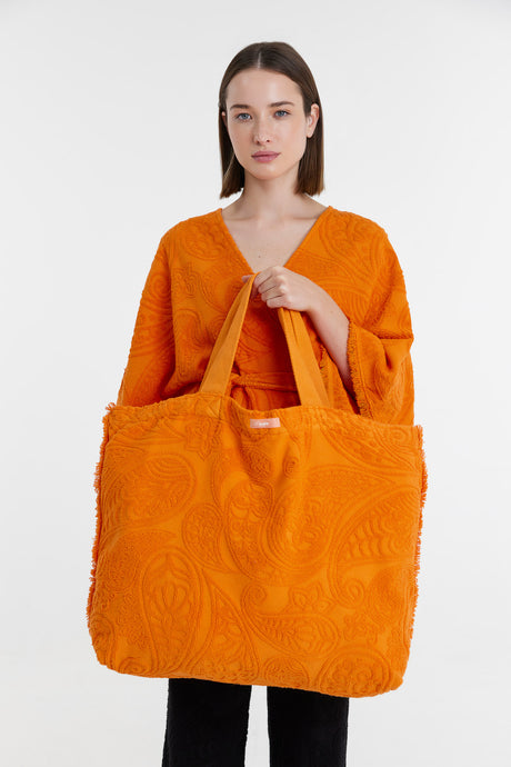 Bright orange oversized tote bag with textured floral patterns, soft fabric handles.