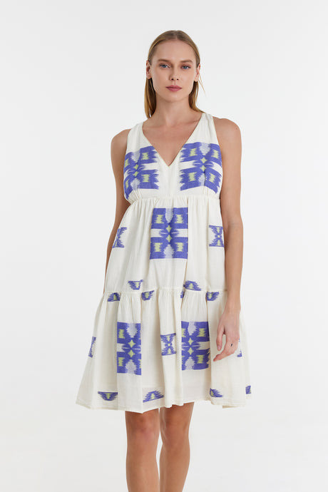 Sleeveless white jacquard short dress with blue geometric pattern and V-neckline.