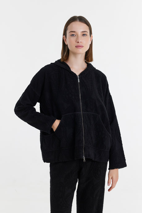 Black zip-up fleece jacket with hood and front pockets, relaxed fit on model.