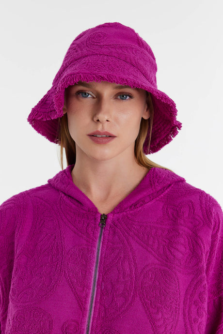 Magenta terry cloth bucket hat with textured pattern worn by model.
