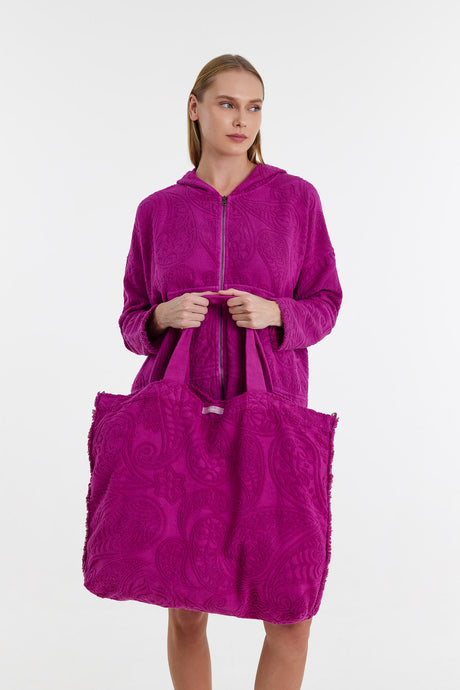Magenta oversized tote bag with textured plush fabric and matching handles worn by model in matching coat.
