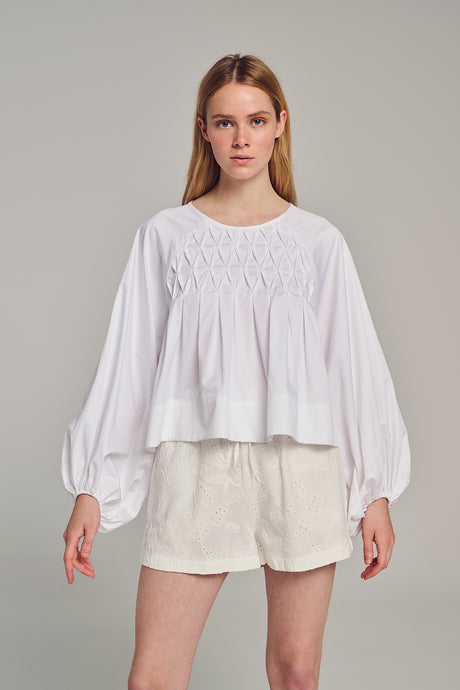 White long-sleeve blouse with gathered yoke detail and billowy sleeves in lightweight fabric.