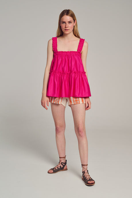 Bright pink sleeveless smocked top with square neckline and ruffle details.
