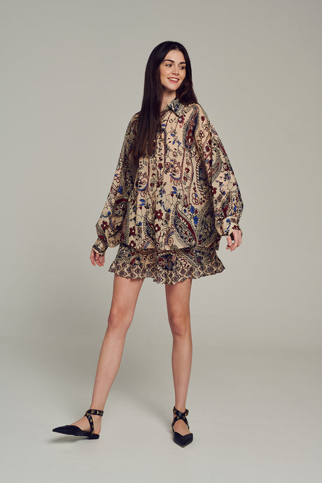 Long-sleeve multi-color printed blouse with relaxed fit and buttoned cuffs worn by model.
