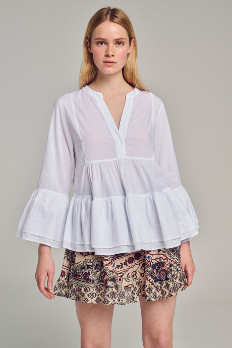 White long-sleeve blouse with tiered ruffle hem and V-neckline with button detail.