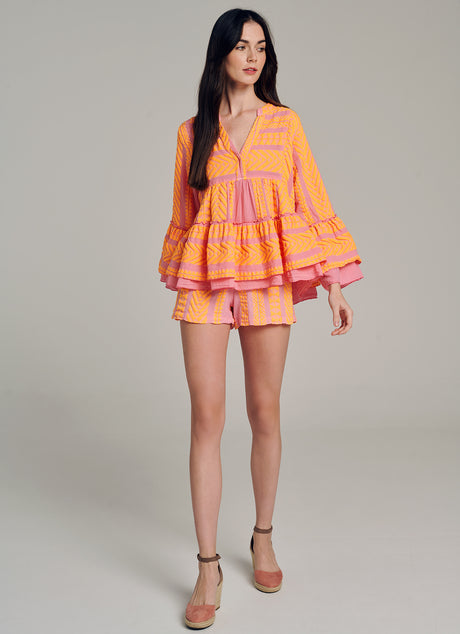 Orange and pink jacquard blouse with tiered bell sleeves and V-neck, paired with matching shorts.