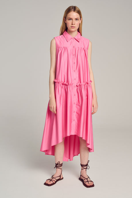 Sleeveless bright pink midi dress with gathered waist and high-low hem, styled with lace-up sandals.