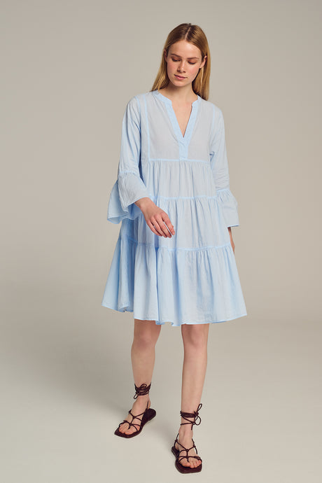 Light blue midi dress with tiered skirt, V-neckline, and voluminous three-quarter sleeves.