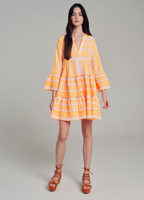 Short orange jacquard dress with white geometric patterns, tiered skirt, and flared sleeves.