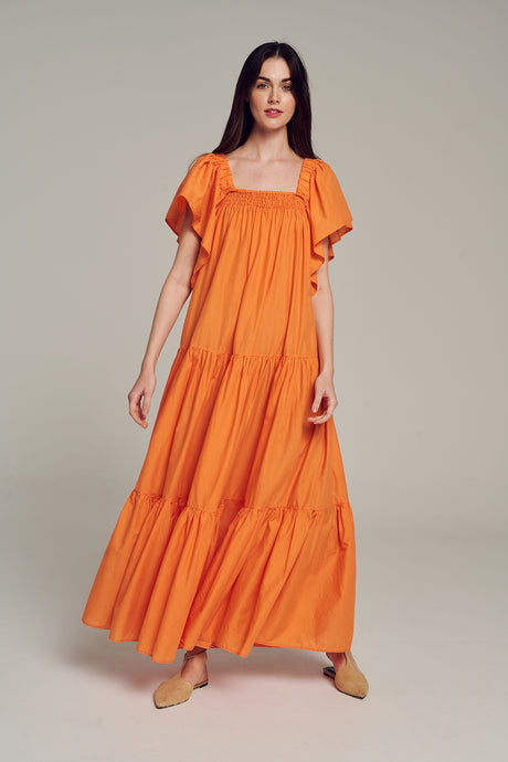 Bright orange midi dress with puff sleeves and tiered skirt, styled with tan flats.
