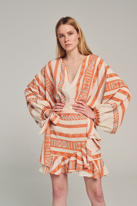 Orange and white jacquard skirt with layered ruffle hem and geometric patterns.