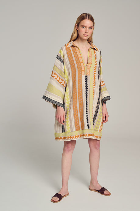 Multicolor jacquard short dress with vertical stripes and wide sleeves worn with flat sandals.