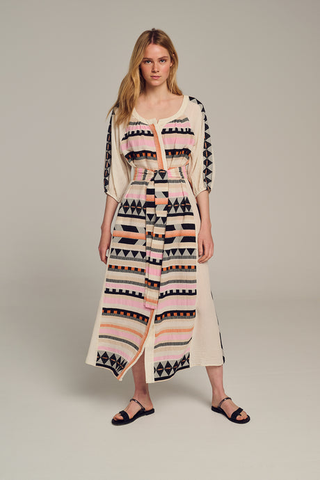 Midi jacquard dress in cream with pink and black geometric patterns, front slit, and three-quarter sleeves.