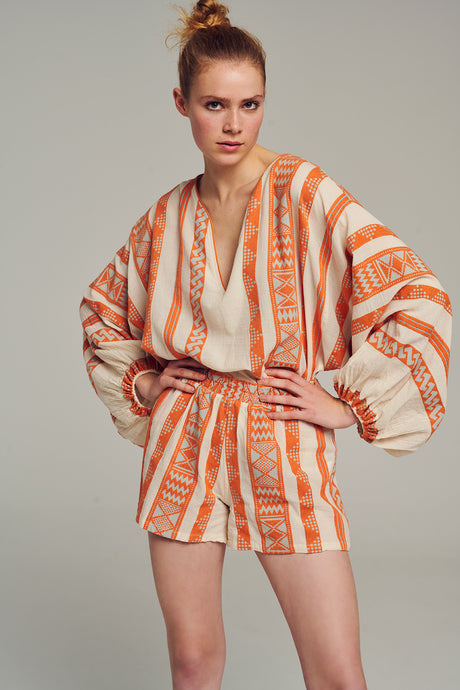 Orange and beige jacquard high-waist shorts with vertical stripes and textured pattern.