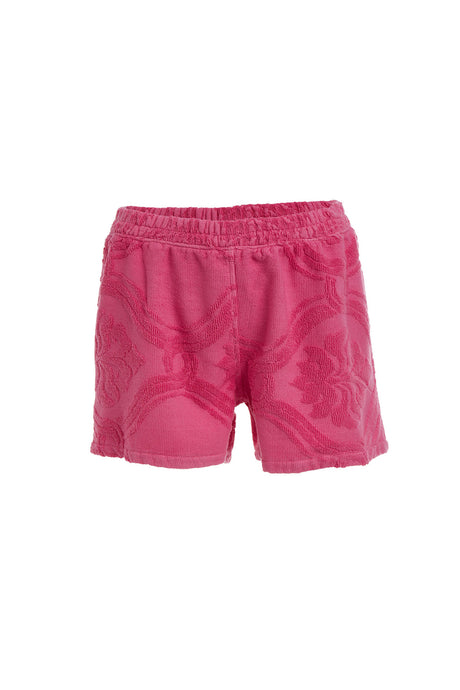Pink terry cloth shorts with elastic waistband and subtle floral pattern.