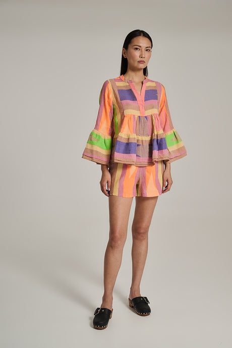 Women’s blouse with orange, pink, green, and purple vertical stripes and wide bell sleeves.