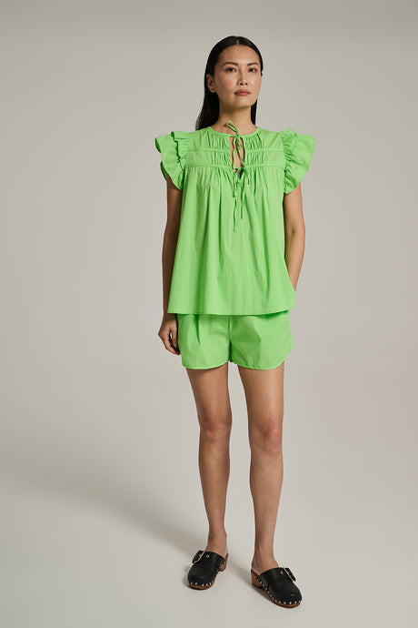 Green short-sleeve ruffled blouse with keyhole neckline and matching shorts in lightweight fabric.