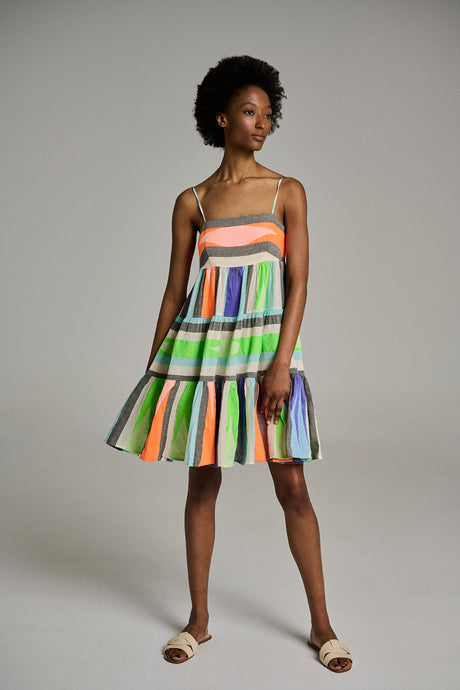 Sleeveless jacquard dress with colorful vertical stripes and a tiered skirt, paired with beige slide sandals.