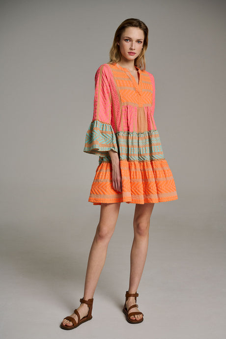 Short tiered pink and orange jacquard dress with bell sleeves and patterned blue trim.