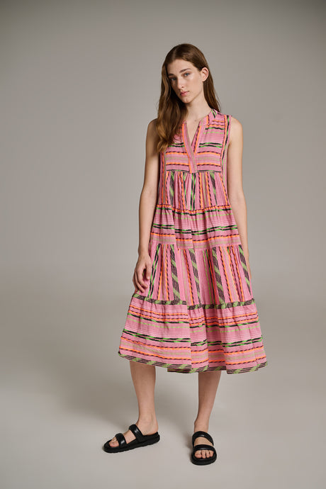 Sleeveless mid-length pink and orange jacquard dress with tiered skirt and V-neck, worn with black sandals.