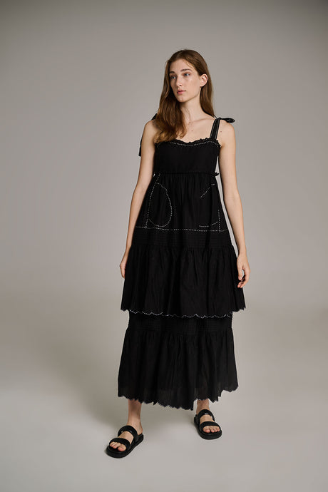 Black sleeveless tiered maxi dress with tie straps and subtle embroidery detail.
