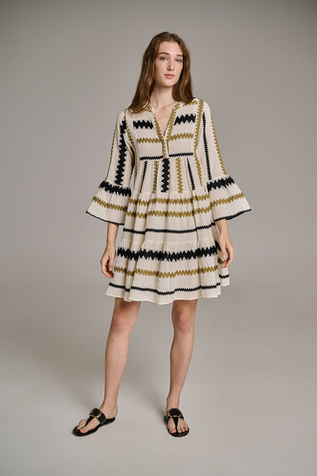 Short khaki and offwhite jacquard dress with flared sleeves and tiered skirt, worn with black sandals.