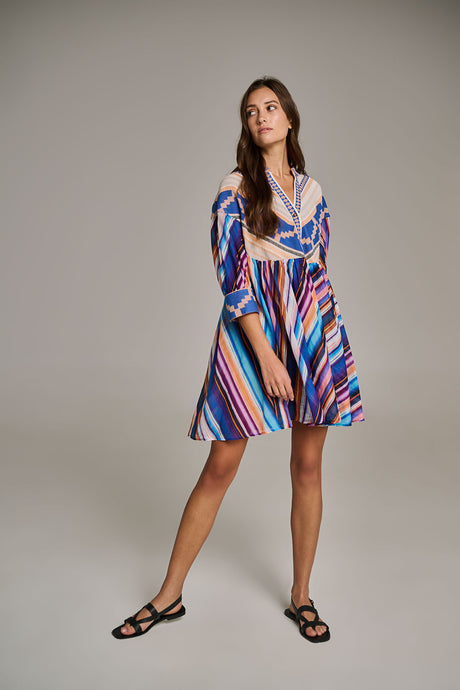 Blue and purple striped short dress with three-quarter sleeves and v-neckline, worn with black sandals.