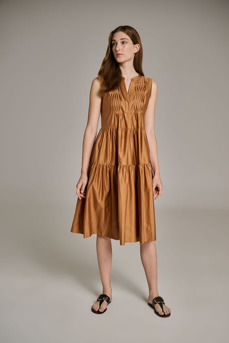 Sleeveless camel midi dress with tiered skirt and V-neck, styled with black flat sandals.
