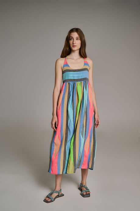 Sleeveless midi dress with vertical rainbow stripes and a smocked bodice, worn with black sandals.
