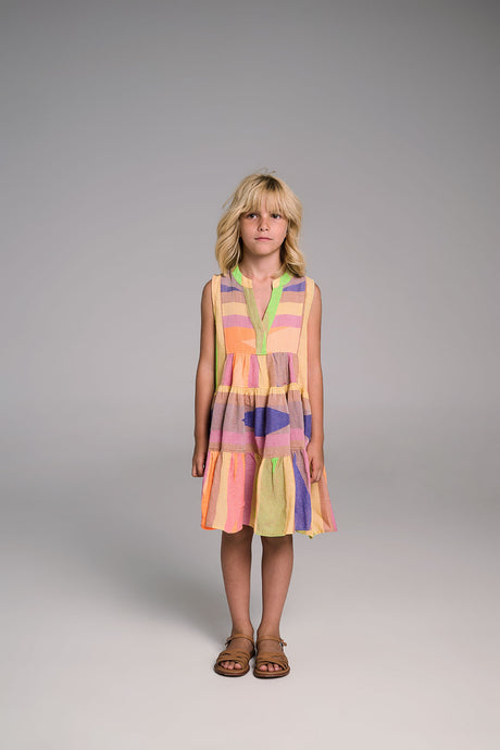 Sleeveless V-neck dress with multicolor pastel stripes and ruffled hem, worn with brown sandals.