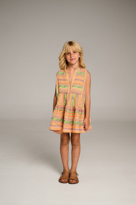 Sleeveless beige and orange striped dress with a flared skirt worn by a child.